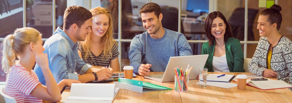 Group of young colleagues using laptop at office