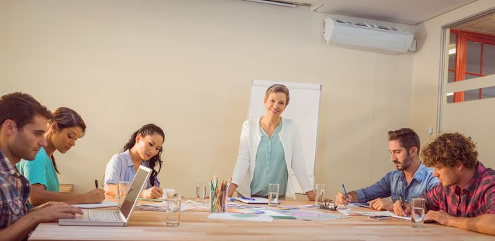 Casual young businesswoman giving a presentation to her colleagues