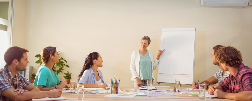 Casual young businesswoman giving a presentation to her colleagues