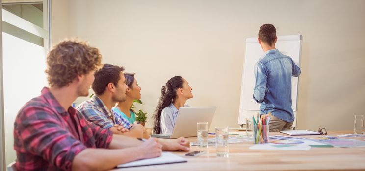 Casual young businessman giving a presentation to his colleagues