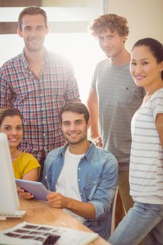 Portrait of creative business team gathered around a tablet in the office