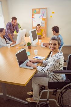 Upward view of a creative casual businesswoman in wheelchair in the office