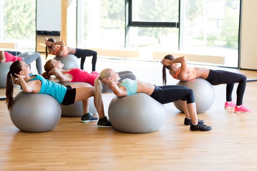 fitness, sport, training and lifestyle concept - group of smiling women with exercise balls in gym