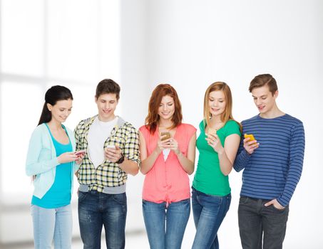 education and modern technology concept - smiling students with smartphones