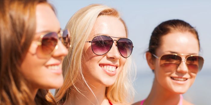 summer vacation, holidays, friendship and people concept - close up of smiling young women in sunglasses