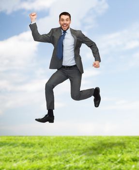 business, education and people concept - smiling happy businessman jumping