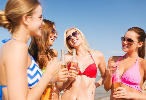 summer vacation, holidays, travel and people concept - group of smiling young women sunbathing and drinking on beach