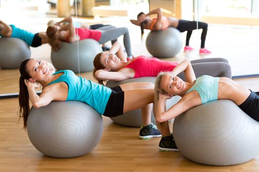 fitness, sport, training and lifestyle concept - group of smiling women with exercise balls in gym