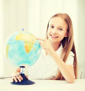 education and school concept - little student girl with globe at school