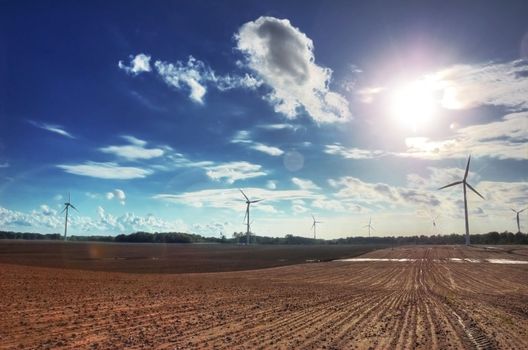 Windmills on the plowed field. HDR picture.