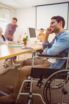 Creative businessman in wheelchair on the phone at office