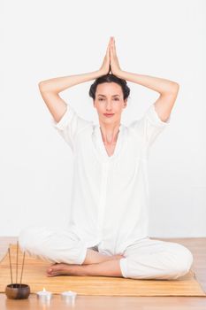 a woman in a meditation position against a white background