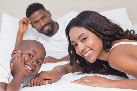 Happy family on the bed at home in bedroom