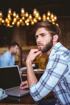 young man working on his computer at the cafe