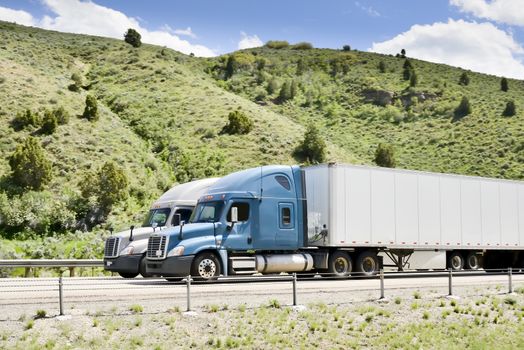 Shot of a big trucks traveling along the highway of the america.