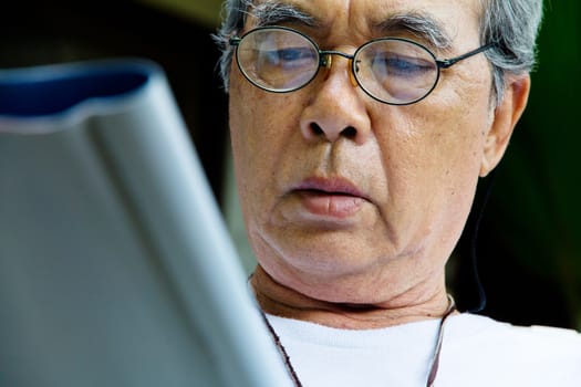 Senior man relaxing at home reading a book