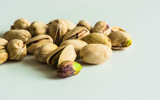 a group of pistachios, one is without its shell