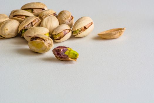 a group of pistachios, one is without its shell