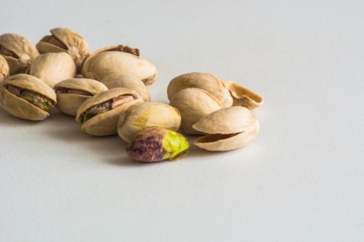 a group of pistachios, one is without its shell