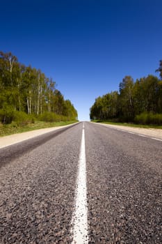   the small rural asphalted road photographed in summertime of year. Belarus