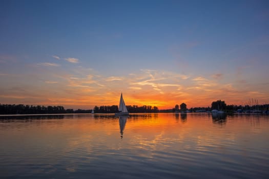 sunrise / sunset at a lake with sailing boats