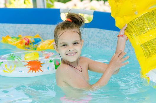 Six year old girl Europeans bathed in a small suburban pool