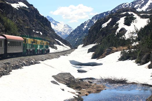 Old train traveling through snowy mountain