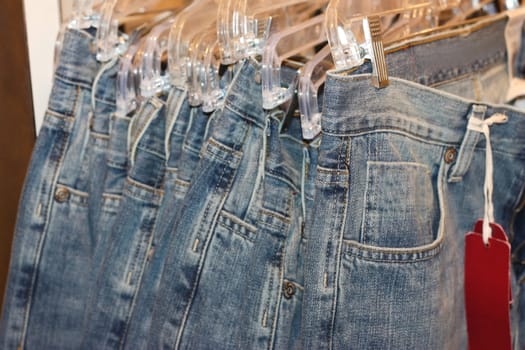 Row of jeans hangind in the store