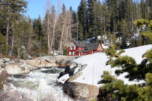 Beautiful cabin in snow near waterfall