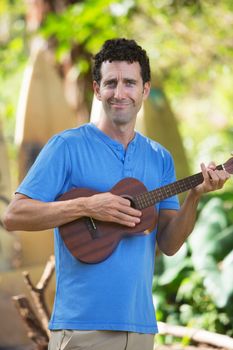 Cute male playing ukelele outdoors in Hawaii