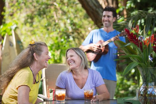 Two mature happy women with ukelele player