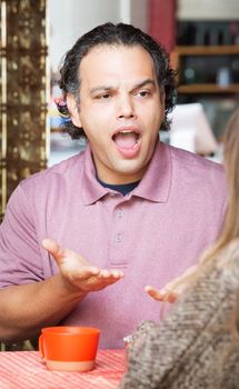 Frustrated man with woman at coffee house indoors