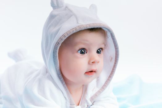 Cute baby in the hood on a blue blanket