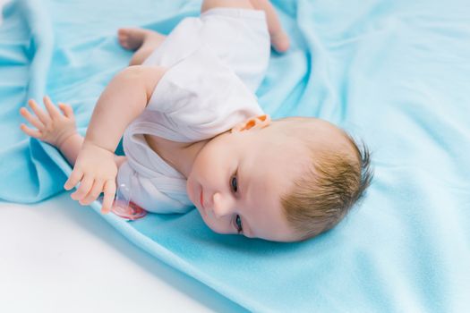 Cute baby lying on a blue blanket