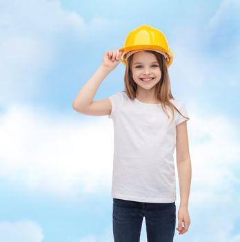 construction and people concept - smiling little girl in protective helmet