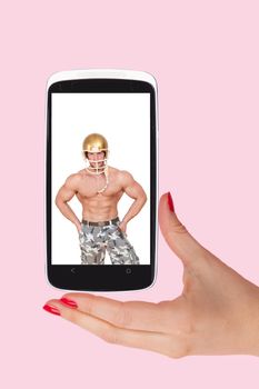 Online dating. Female hands holding smartphone with picture of handsome man isolated on pink background. Flirting and relationship in the information age.