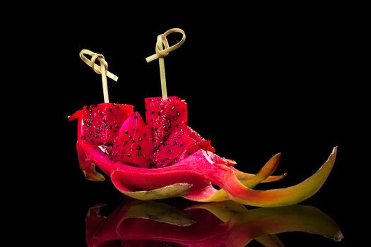 Pink dragon fruit isolated on black background. Healthy delicious tropical fruit eating. 