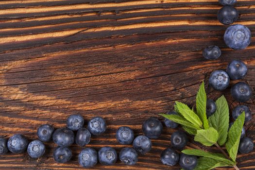 Fresh blueberry background with copyspace. Ripe fresh blueberries on rustic wooden background, top view. Healthy summer fruit eating. 