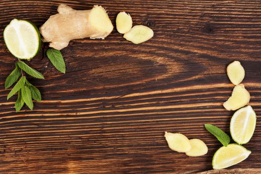 Healthy fruit eating. Ginger and lime on wooden table, top view with copyspace. Healthy fresh fruit eating. 