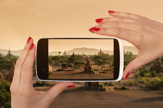 Bagan snapshot on smartphone screen in female hands with red nails. Female travel, vagabonding and backpacking. 