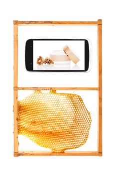 All information on your fingertips. Honeycomb and smartphone with royal jelly cosmetics. Information age concept.