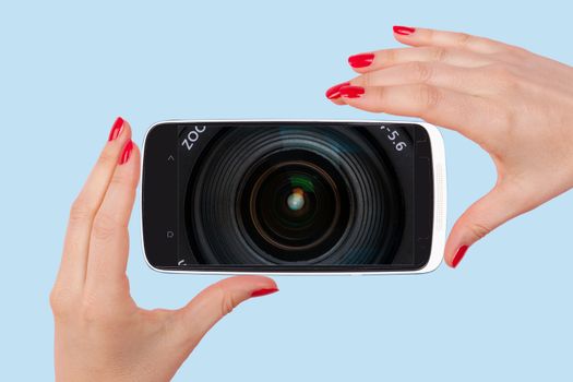 Selfie. Female hands with red nails holding smartphone with optical lens on screen. Modern social media picture communication.