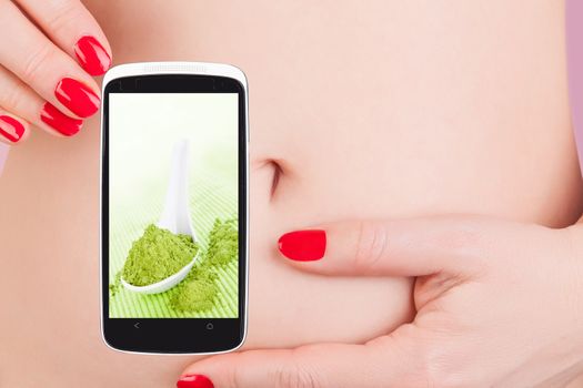 Detox app on smartphone and beautiful female body and belly. Detox and healthy living in the information age.