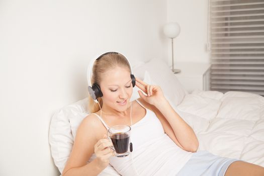 Pretty woman listening to music and drinking coffe