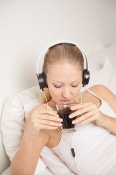 Pretty woman listening to music and drinking coffe