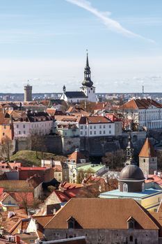 Top view of Tallinn with small houses and big churches, on blue sky background.