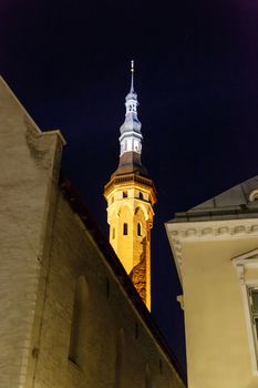 Front view of medieval Lutheran Church of the Holy Ghost in Tallinn, Estonia, in dark on navy blue sky background.