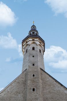 Close up detailed bottom view of medieval Lutheran Church of the Holy Ghost in Tallinn, Estonia, on blue cloudy sky background.