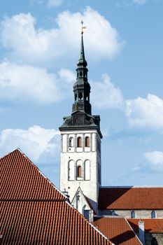 Front view of the medieval former St Nicholas Church, in Tallinn, Estonia, dedicated to Saint Nicholas, on blue cloudy sky background.