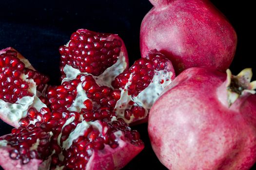 Photo of open pomegranate on black background